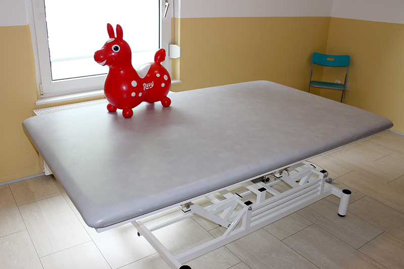 Kinderbehandlungsraum mit Therapieliege und Spieltier